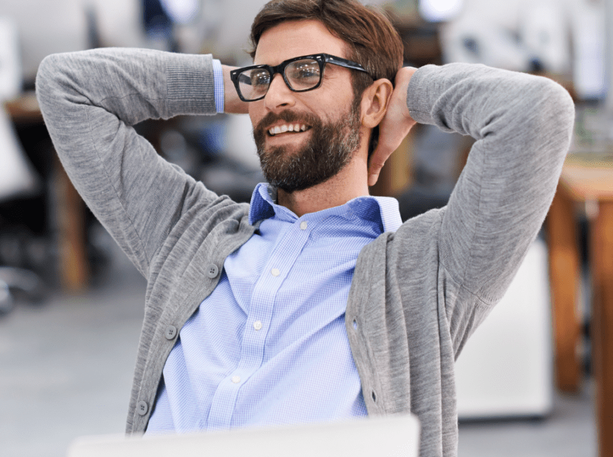 Homme s'étirant sur sa chaise de bureau, symbolisant la flexibilité et les avantages de l'externalisation.